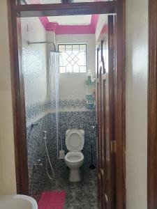 y baño con aseo y ducha. en Royals apartment en Mombasa