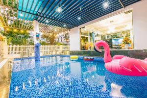ein Pool mit zwei rosa Flamingos im Wasser in der Unterkunft Villa FLC Sầm Sơn Sao Biển SB106 in Thanh Hóa