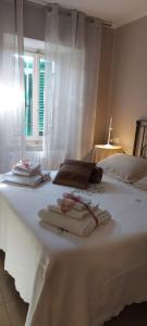 a white bed with towels on it with a window at Linda's Holiday Home in Roccastrada