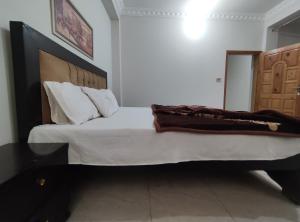 a bedroom with a large bed with a wooden headboard at Marina Residency in Muzaffarabad