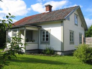 una pequeña casa blanca con techo rojo en Enköping Cottage en Enköping