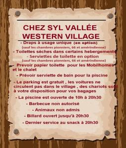 ein Schild für das westliche Dorf Westville an einer Holzwand in der Unterkunft Camping Syl-Vallée Western Village in Bouglon
