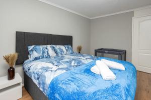 a bedroom with a blue and white bed with two pillows at Urban Gem in Longbridge +32 photos