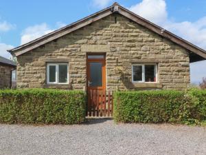a stone house with a wooden door and windows at Bridge End in Chatburn