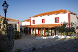 um grande edifício branco com uma luz de rua em frente em Quinta da Relva - Soulful House em Mafra