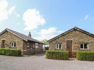 a stone house with a driveway in front of it at Pendleside in Chatburn