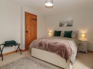 a bedroom with a large bed with green pillows at Vallum Rest in Carlisle