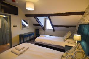 ホークスヘッドにあるRed Lion Innのベッド2台と窓が備わるホテルルームです。