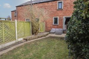 a brick house with a fence in the yard at Vallum Rest in Carlisle