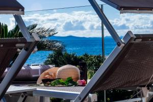 a table with a hat and a view of the ocean at Dedaj Resort - Villa Delux in Zadar