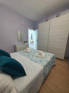 een slaapkamer met een groot bed met blauwe en witte lakens bij La barchetta in Gela