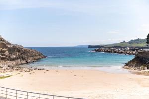 a beach with a fence next to the ocean at Carla,centro Llanes a 350m playa in Llanes