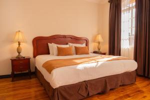 a bedroom with a large bed and two lamps at Casa Conde Hotel & Apartamentos in San José