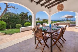 a dining room table with chairs and an umbrella at Villa Estrellas in Sant Lluis