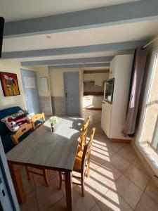 cocina y comedor con mesa de madera y sillas en F2 apartments with panoramic sea views en Farinole