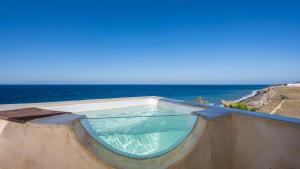 a swimming pool with the ocean in the background at Michelangelo Beach Villa in Oia