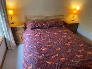 a bed in a bedroom with two nightstands and two lamps at Mill Cottage, Upper Hulme in Upper Hulme