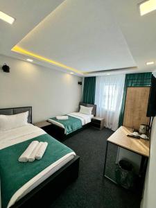 um quarto de hotel com duas camas e uma mesa em Garden Hotel em Akhalk'alak'i