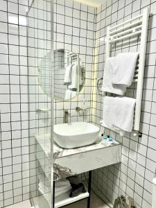 uma casa de banho branca com um lavatório e um espelho em Garden Hotel em Akhalk'alak'i