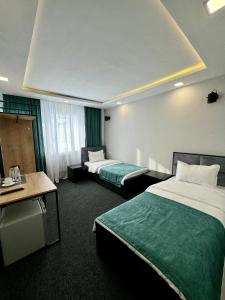 um quarto de hotel com duas camas e uma secretária em Garden Hotel em Akhalk'alak'i