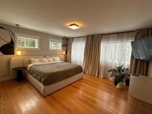 a bedroom with a large bed and two windows at Modern House Family Retreat in Bar Harbor +35 photos