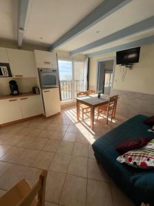 cocina y sala de estar con mesa, cocina y mesa de comedor. en F2 apartments with panoramic sea views, en Farinole