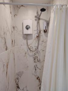 a bathroom with a shower with a shower curtain at Linroy Guest House in Skegness