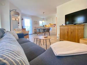 a living room with a couch and a flat screen tv at Dünenresidenz Karlshagen - Ferienwohnung Lindenweg 8b in Ostseebad Karlshagen