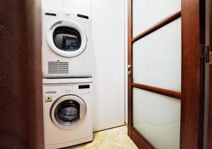 una lavadora y una lavadora y secadora en una habitación en Aida Guest House - Decimomannu, en Decimomannu