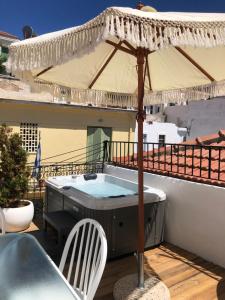 un bain à remous sur un balcon avec un parasol dans l'établissement Evagelia's Villas, à Skopelos