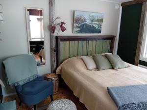a bedroom with a bed and a blue chair at Experience accommadation Eco-Unela in Rovaniemi