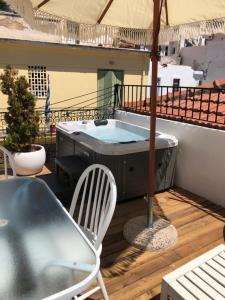 - un bain à remous sur un balcon avec une table et des chaises dans l'établissement Evagelia's Villas, à Skopelos