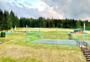 a tennis court with a net in a field at Horský hotel Brans in Malá Morávka