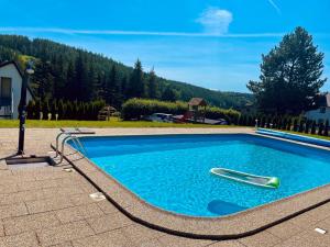 a swimming pool with a hose in the water at Horský hotel Brans in Malá Morávka
