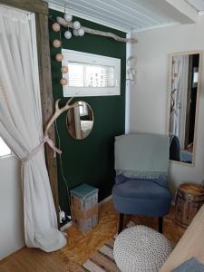 a room with a blue chair and a mirror at Experience accommadation Eco-Unela in Rovaniemi