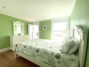a green bedroom with a bed and a window at Beach Front Luxury Vacation Rental On Lbi in Surf City