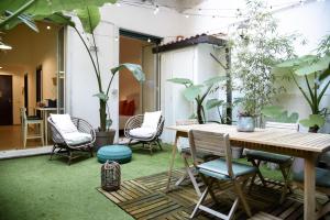een terras met een tafel, stoelen en planten bij Jama Maison Garden in Napels
