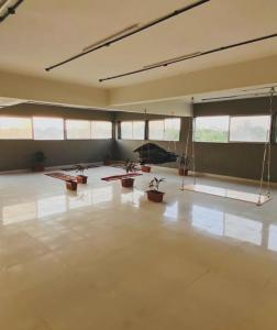 una habitación vacía con macetas y ventanas en Dhanak villa, en Surat