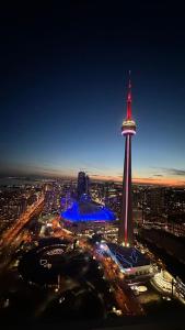 uitzicht op een stad 's nachts met de televisietoren bij DOWNTOWN, LUXURY CONDO, CN TOWER, ROGERS CENTER, SCOCIA ARENA, UNOBSTRUCTED VIEW in Toronto
