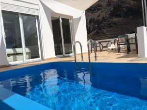 a blue swimming pool in a house with a patio at CasitaCalera in Calera +4 photos