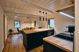 a kitchen with black cabinets and a kitchen island at Jizerína in Bedřichov +49 photos