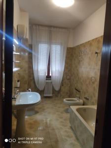 La salle de bains est pourvue de 2 lavabos, d'une baignoire et de 2 toilettes. dans l'établissement Ampio appartamento fino a 9 ospiti, à Porto San Giorgio