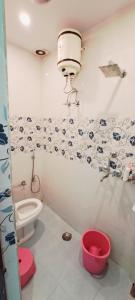 a bathroom with a toilet and a bucket in it at Hotel Ananya Inn in Varanasi