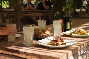 a wooden table with plates of food and glasses of milk at Playa Esperanza Tulum in Tulum
