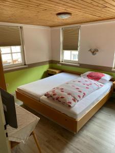 - une chambre avec un lit aux murs verts et des fenêtres dans l'établissement Zur Linde, à Mühlheim an der Donau
