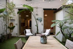 een terras met een houten tafel, stoelen en planten bij Jama Maison Garden in Napels