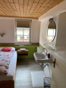 a bathroom with a bed and a sink in a room at Zur Linde in Mühlheim an der Donau