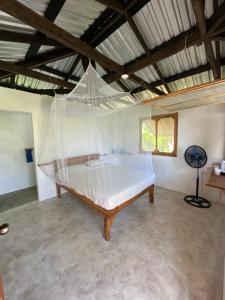Cama en habitación con mosquitera en Silversands Retreat en Corn Island