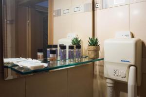 een badkamerbar met een spiegel en een handdoekendispenser bij THOLOS HOTEL in Delfoi