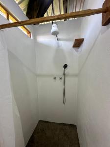 una ducha en una habitación blanca con una luz en la pared en Silversands Retreat en Corn Island